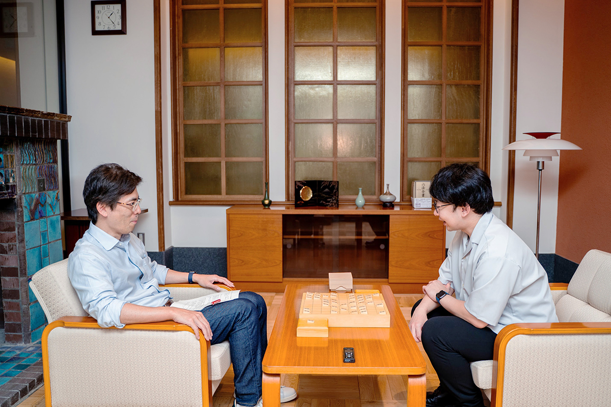 将棋盤を挟んで向かい合って座る谷合廣紀さんと境家史郎先生