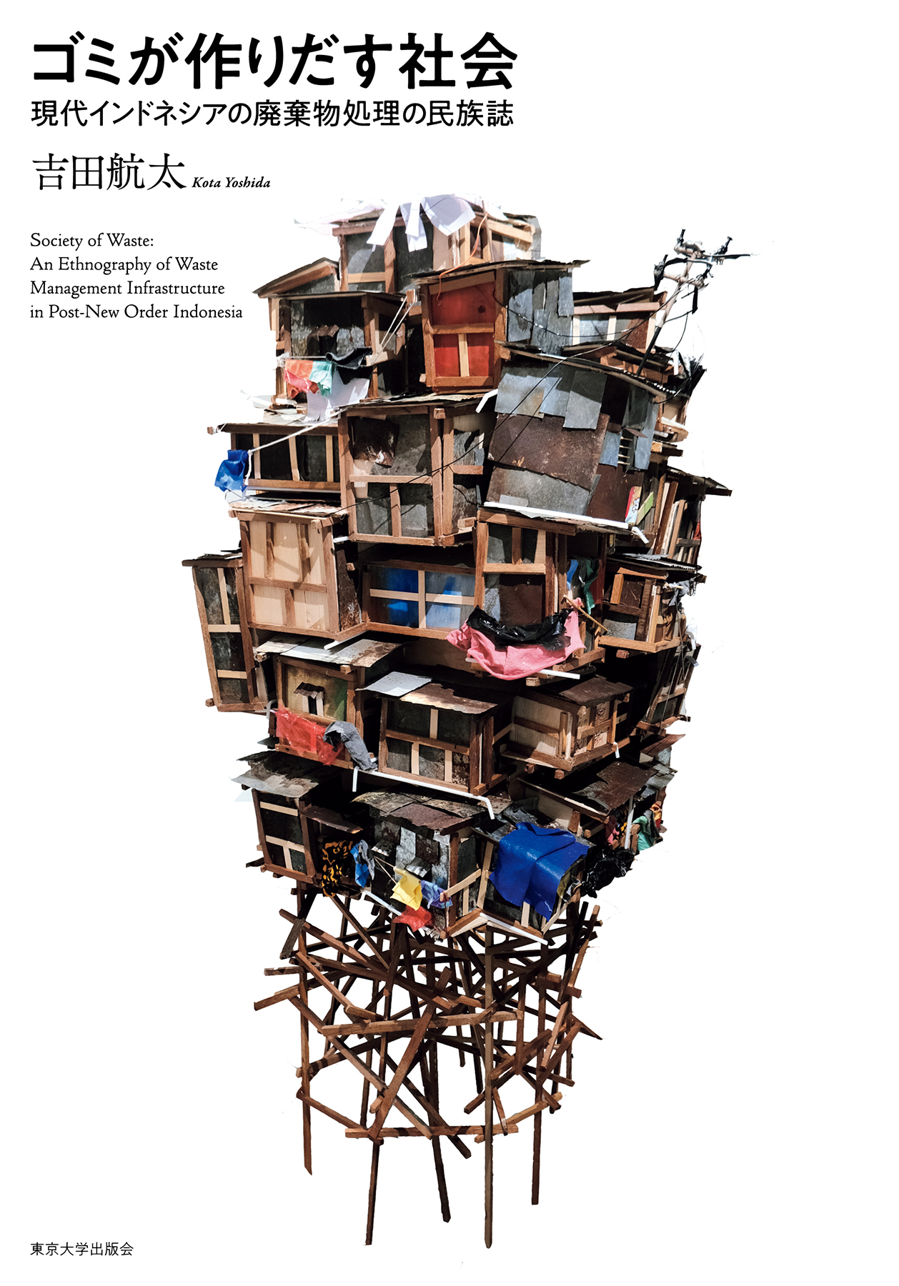 白い表紙に、木材などの廃材を積み上げたイメージ画