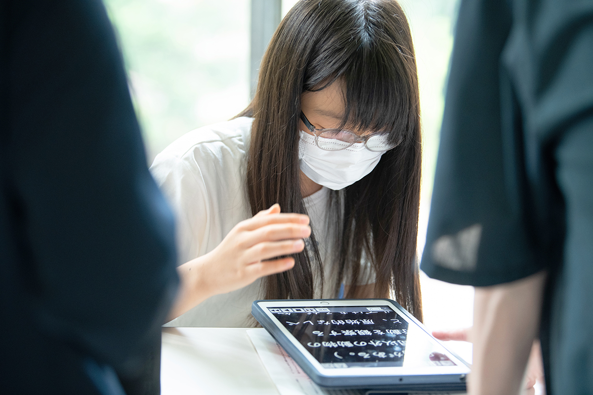 参加者が支援機器（タブレット）に触れている様子